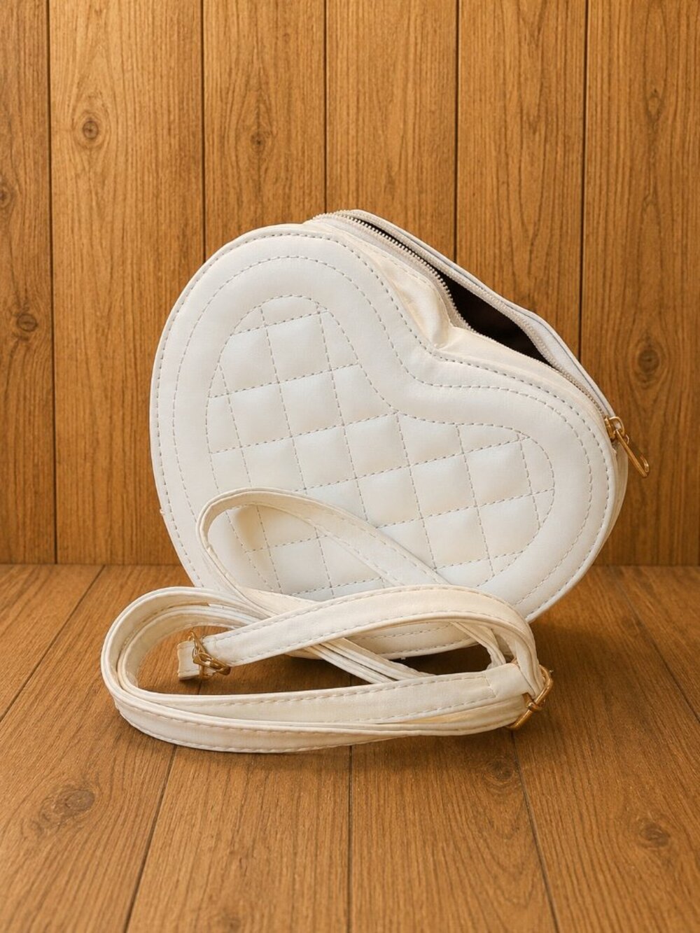 White heart-shaped crossbody handbag featuring quilted stitching